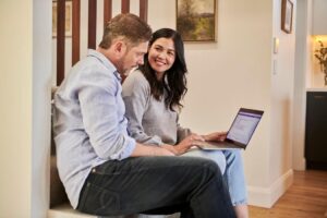 Homem e mulher de negócios analisando dados em notebook.