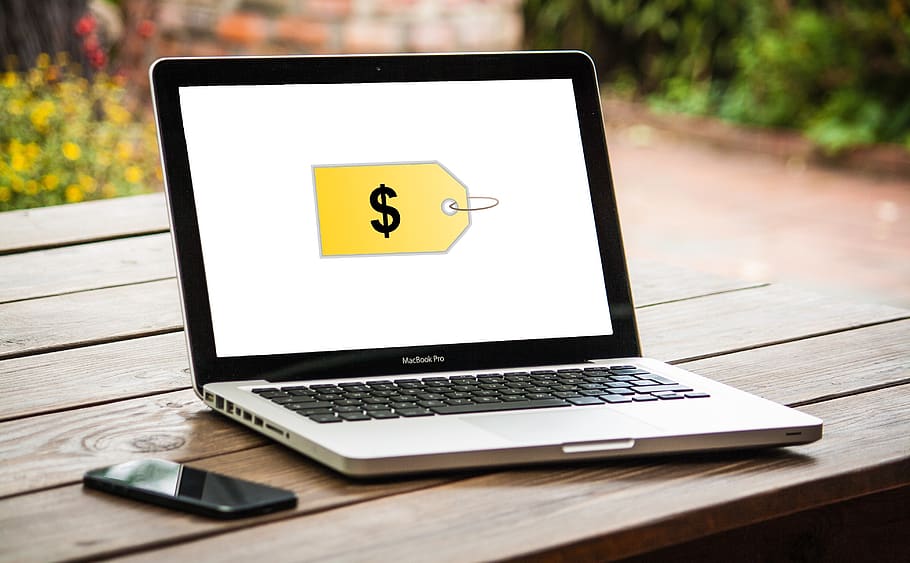 foto de um notebook com uma sigla de dinheiro relacionada à um produto de marketplace online