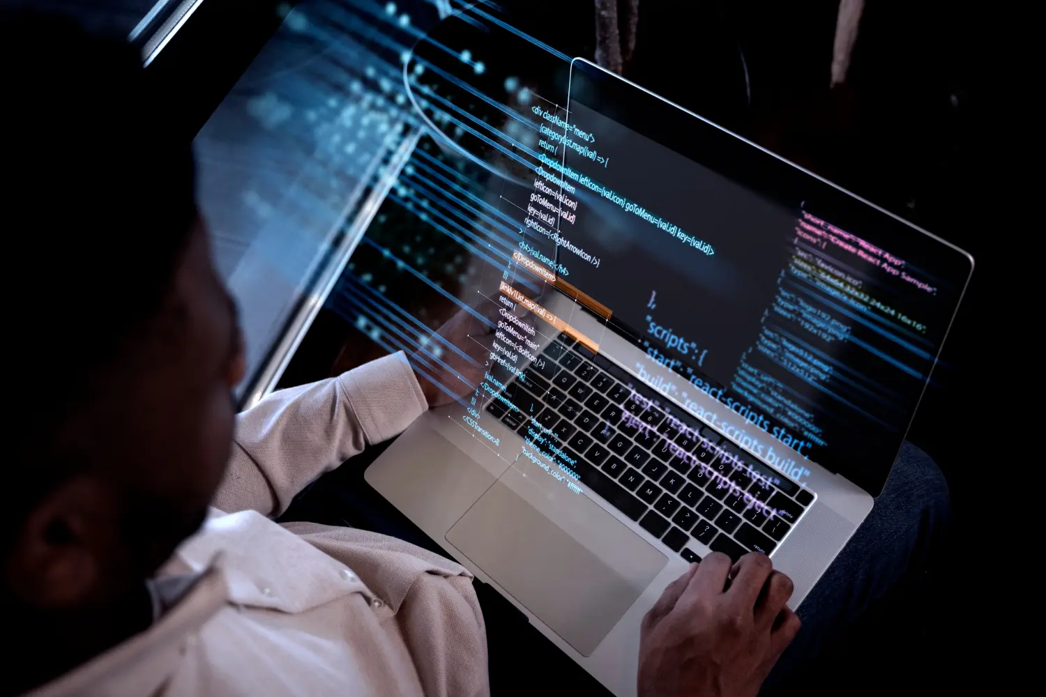 Homem olhando para um notebook, na tela estão códigos de uma linguagem de programação, que simboliza algoritmo do Mercado Livre.