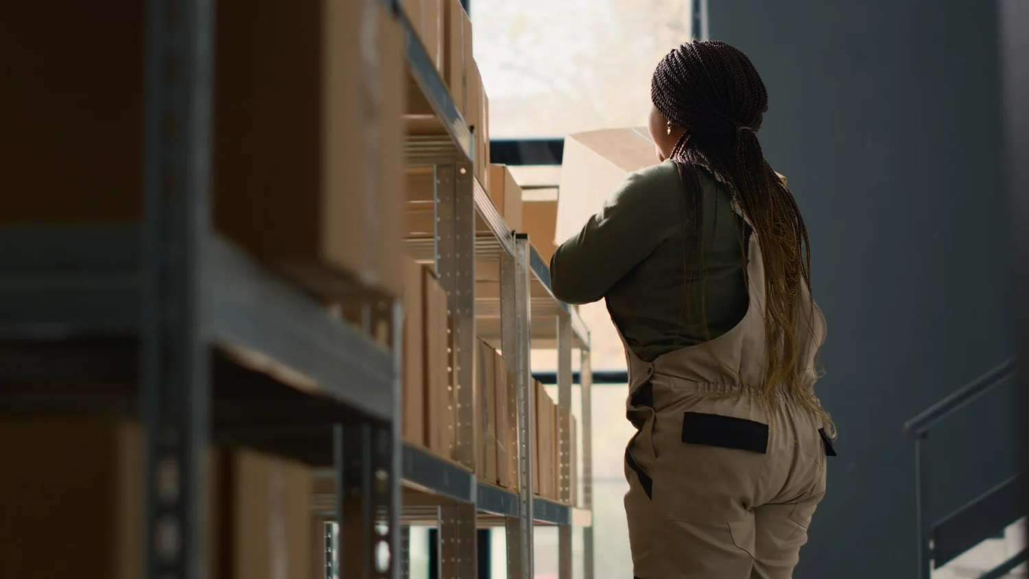 Imagem de uma mulher organizando caixas e analisando processos