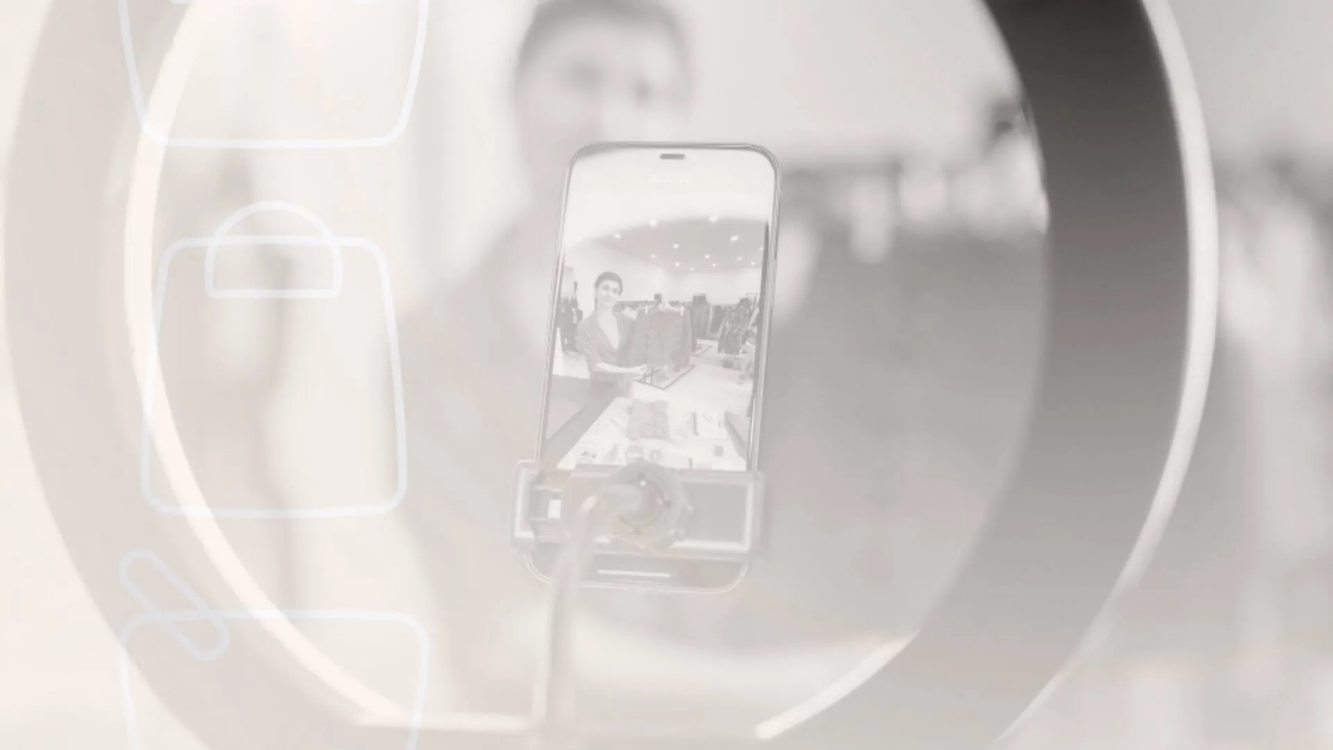 Smartphone grava apresenta&ccedil;&atilde;o de produtos em loja durante live commerce, com ring light ao redor do aparelho.