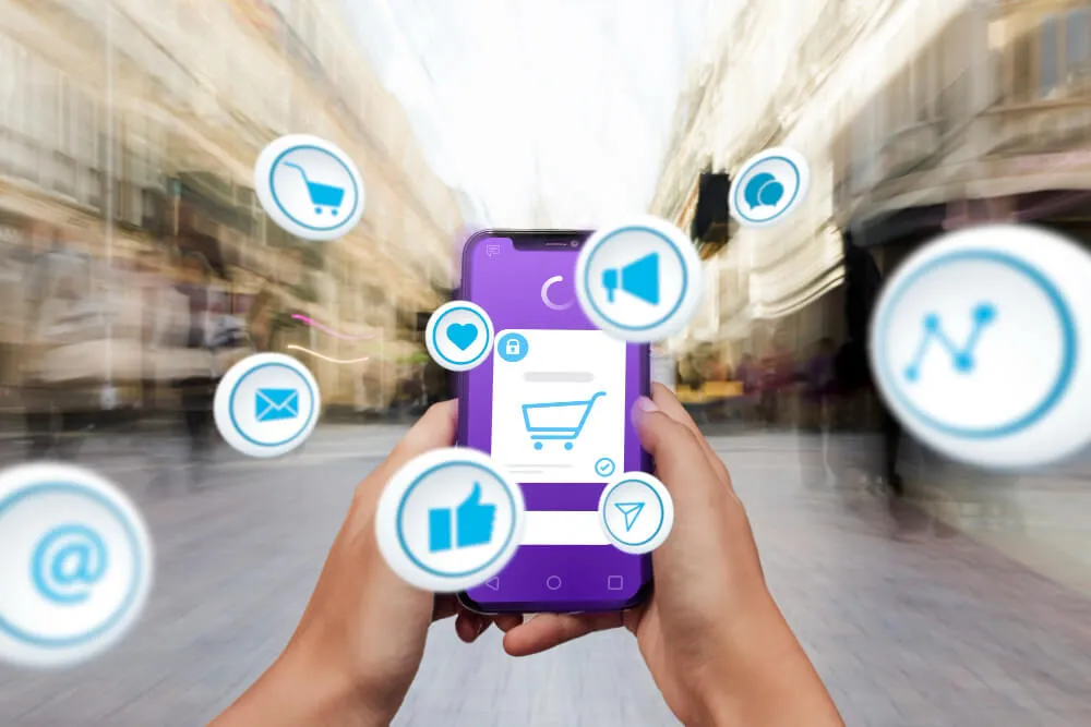 Livelo Shopping representado em compra online pelo celular com ícones de carrinho, comunicação e interação digital.